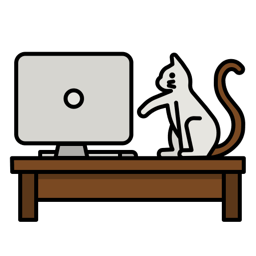Cat sitting at a desk looking at a computer monitor